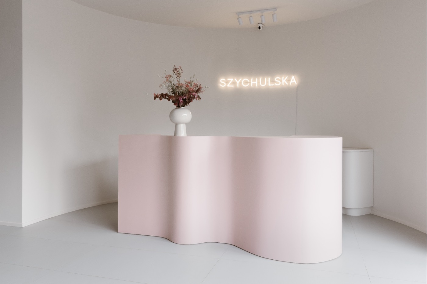 Recepcja salonu — pudroworóżowa falowana lada — salon Szychulska, Gdynia Łowicka 64